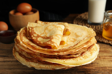 Stack of fresh thin pancakes on wooden table