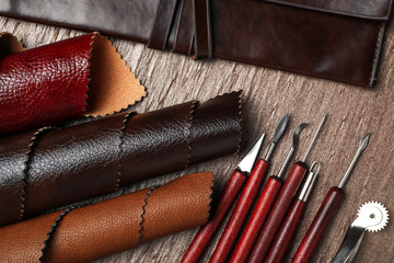 Leather samples and tools on brown table, flat lay