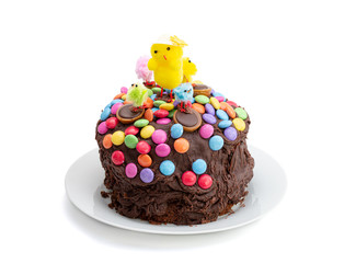 Easter cake on a white background. Fun kids chocolate cake decorated by a child with chocolate frosting covered in colorful chocolate beans and Easter chicks. Top and side view.