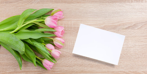 Naklejka na ściany i meble Rosarote Tulpen auf einem hellen Holztisch mit Postkarte