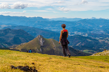 A young woman begins to descend from the top of the top of Mount Txindoki in Guipuzcoa. Basque Country