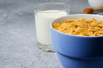 Corn flakes in a plate and milk in a glass. Healthy breakfast. Copy space