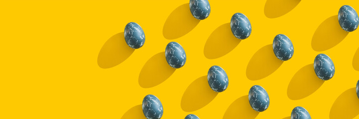 Blue textured colored Easter eggs on bright yellow holiday background backdrop. Spring holiday concept. Copyspace. Flat lay. Top view. Hard light. Long shadow.