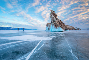 Zwei Wanderer auf dem Eis des Baikalsees vor der Insel Ogoi