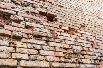 brick wall of old building with holes and cracks on city historical street close view