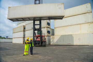 Engineer wearing a helmet standing cargo at the container yard and Check container integrity Before exporting products abroad. Shipping import, export industrial and logistics concept.