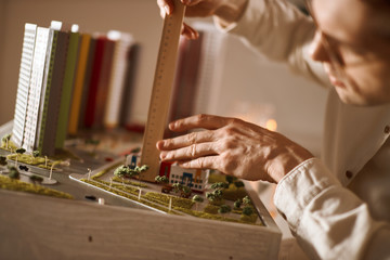 professional architect using engineering tools on model building, close up cropped photo