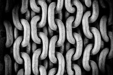 Old rusty chain close-up. Detail of the mechanism. A symbol of strength. Black and white photo. Abstract background.