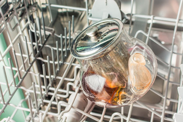 Dirty glass teapot lies in the dishwasher