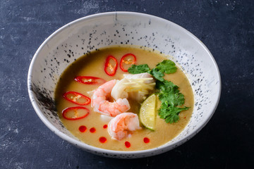thai traditional tom yam kung soup in a white bowl