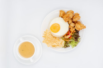 Buttermilk chicken rice with ingredients isolated on white with fried egg and salad.