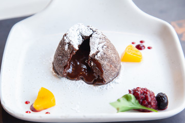 Warm dark chocolate lava cake on white plate