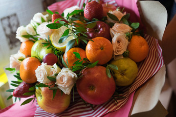 fruit and berry bouquet with roses in a package