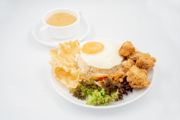 Buttermilk chicken rice with ingredients isolated on white with fried egg and salad.