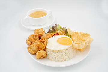 Buttermilk chicken rice with ingredients isolated on white with fried egg and salad.