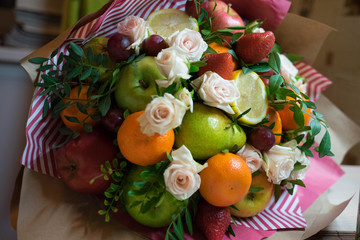 fruit and berry bouquet with roses in a package