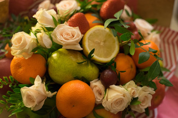 fruit and berry bouquet with roses in a package