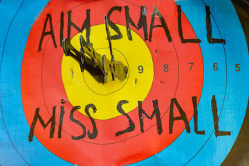 Colorful target practice with a message Aim small miss small and knives, bullseye, Romania