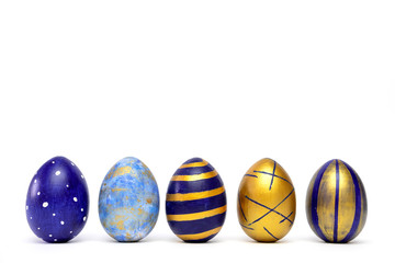 Five easter eggs trendy colored classic blue, white and golden decorated on white table. Happy Easter card with copy space for text. Minimal style.