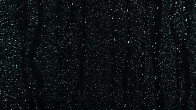 Rain water droplets trickling down the window pane at night