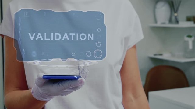 Doctor in medical glove against background of doctor's office with HUD hologram text Validation. Hand holds futuristic holographic gadget. Medical technology concept of the future