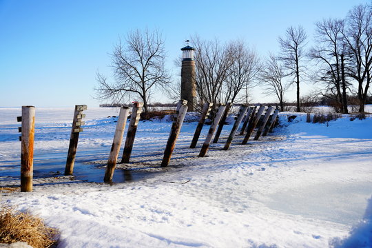 Old Vintage Historical Asylum Point Lighthouse Standing Off Of The Frozen Lake Winnebago Out In Oshkosh, Wisconsin During The Cold Winter Season.