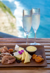 Italian antipasti with champagne or sparkling wine. Italian antipasti wine snacks set. Cheese variety, Mediterranean olives, pickles, Prosciutto di Parma, nuts and other appetizers