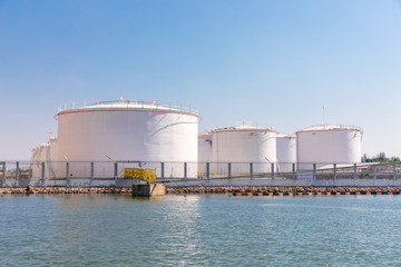 White fuel storage tank in an industrial area near the river
