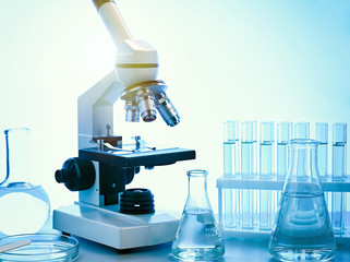 Microscope with test tubes and laboratory glassware.
