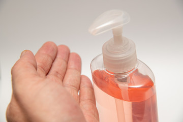 Clear pink hand sanitizer in a clear pump bottle isolated. Hand sanitizer is used for killing germs, bacteria and viruses, some of which can cause coronavirus COVID-19 H1N1 flu or swine flu.