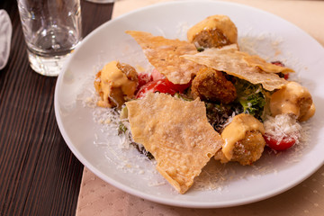 Salad with vegetables and parmesan on a table in a restaurant