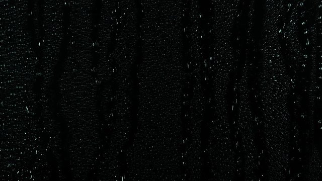 Rain water droplets slowly trickling down the window pane at night