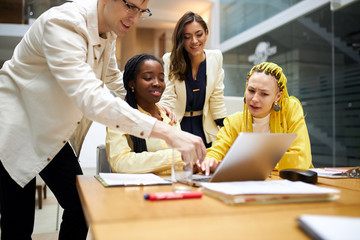 young cheerful man and women looking at photos, man showing photos after having holidays, young positive people in casual stylish clothes working with computer