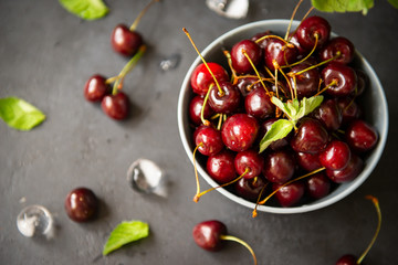 red ripe cherry berries in a plate on a dark