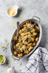 Paste Pipa Rigate and Mushrooms champignon fried in soy sauce, with pepper, parmesan cheese and steamed onions in an old metal bowl on an old vintage table. Selective focus.
