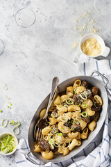 Paste Pipa Rigate and Mushrooms champignon fried in soy sauce, with pepper, parmesan cheese and steamed onions in an old metal bowl on an old vintage table. Selective focus.