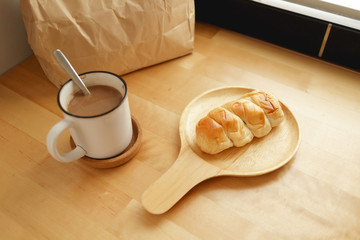 Bakery breakfast set of hot cocoa and baked bread on table.