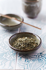 Dried Green Tea Leaves on Bright Background. Close up.