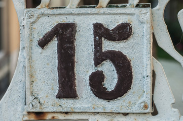 Old retro weathered cast iron plate with number 15 closeup