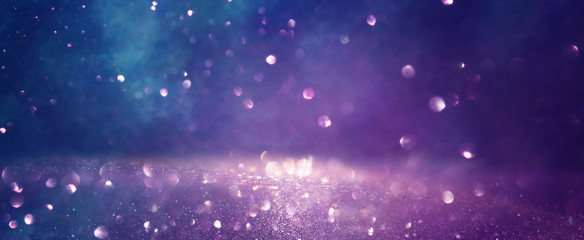 background of abstract glitter lights. gold, blue and purple. de focused