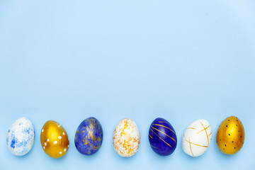 Happy Easter. Frame for text made of easter eggs trendy colored classic blue, white and golden on blue. Minimal style, top view, flatlay, copy space