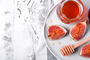 Pieces of figs drizzled with honey on white ceramic plate