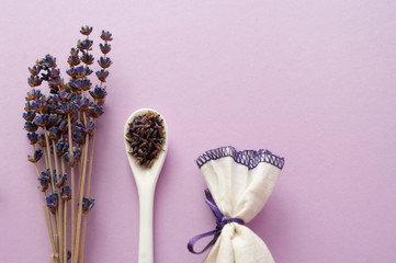 Dry lavender flowers, ceramic spoon, fabric sachet, herbal tea.