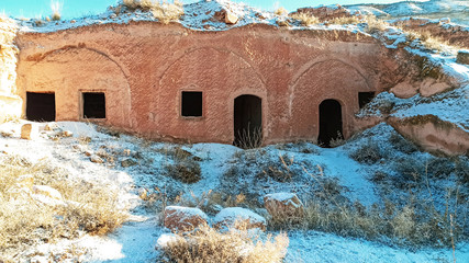 Ancient stone cave houses carved into the volcanic rock in Cappadocia, Turkey