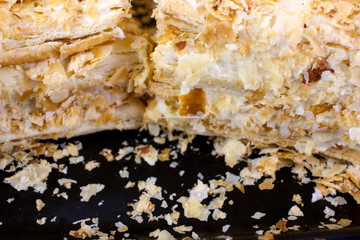 baked puff pastry Napoleon cake on a black background