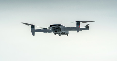 Quadrocopter drone hangs in the air. Shooting photos and videos from a height. Modern technologies of unmanned vehicles
