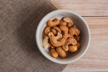 Dried Cashew Nuts food snack  organic nut with salted in the little white bowl on wood background table 