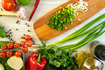 High Angle Still Life View of Knife and Wooden Cutting Board Surrounded by Fresh Herbs and Assortment