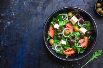 healthy salad olives, lettuce, tomato and cheese feta (greek salad, tasty vegetables snack) menu concept background. top view. copy space for text