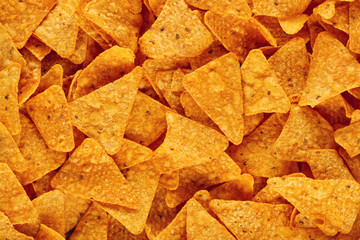 Heap of Mexican nachos or tortilla chips as texture background - obrazy, fototapety, plakaty